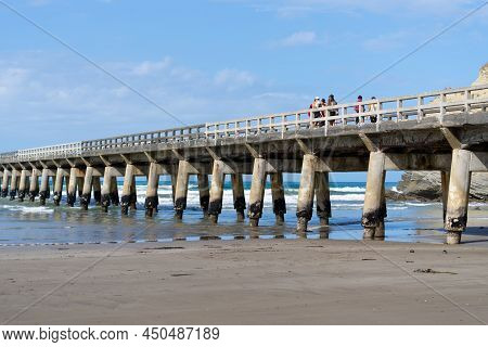 Tolaga Bay New Zealand - February 5 2022; Group Of People Walking Along Long Wharf With Repeating St