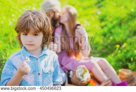 Family On Picnic Outdoor. Parents With Kid In Garden Or Park. Parenthood Together Leisure. Wife And 