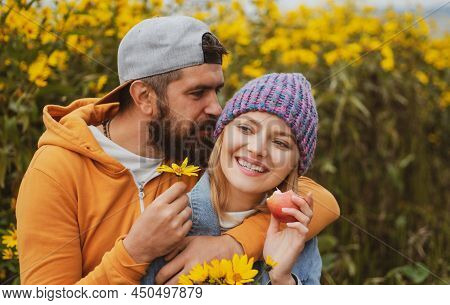 Sensual Portrait Of Young Couple In Love In Autumn Park With Flovers. Loving Couple Embracing And Ki