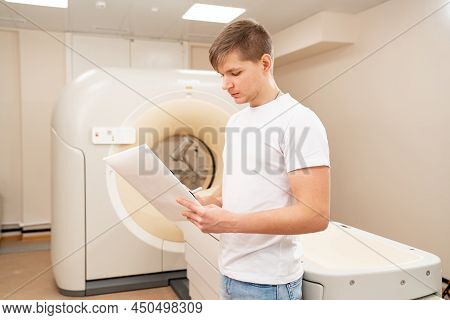 Engineer Fills After Maintenance Documents. Computer Tomograph.
