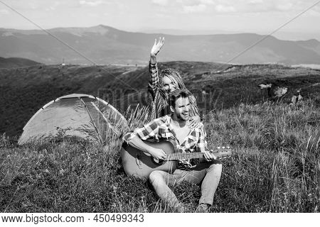 Travel Couple Enjoying Wanderlast View, Woman With Arm Up In Excitement At Mountain Background. Happ