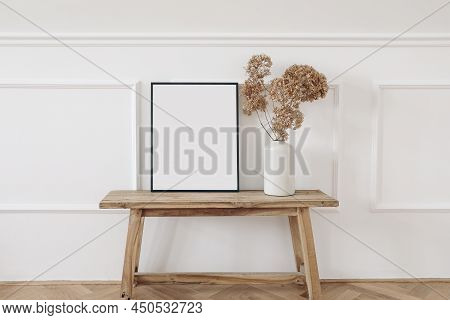 Vase With Dry Hydrangea Flowers On Old Wooden Bench. Blank Black Picture Frame Mockup. White Wall Mo