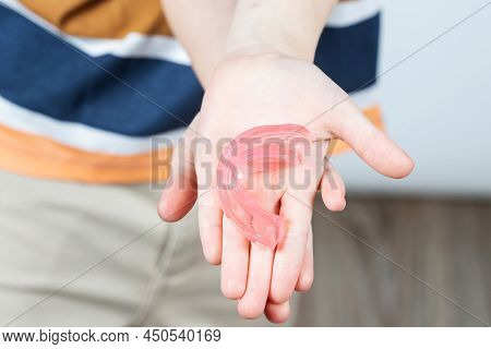 Cute Little Girl With Blond Hair Is Holding A Pink Dental Myofunctional Trainer