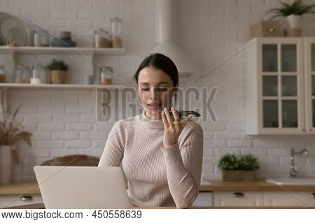 Woman Works On Laptop And Speaks To Client On Speakerphone