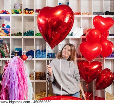 Woman With A Large Red Ball Of Foil In The Shape Of Heart.