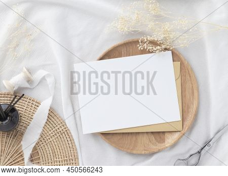 Blank Greeting Card Invitation Mockup 5x7 On Brown Envelope With Dried Flowers On Pastel Green Backg