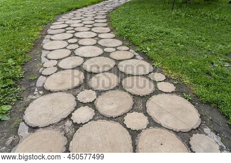 The Path Is Laid Out Of Round Sections Of Wood. High Quality Photo, Paths In The Park From Sawn Wood