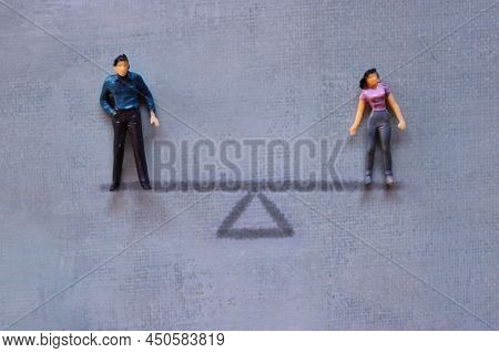 Gender Equality Concept. Miniature Man And Woman Standing On Balance Scale.