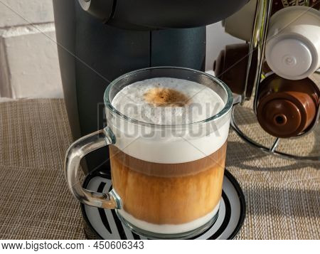 Close-up Shot Of Hot Cappuccino Coffee In A Glass Mug With Top Layer Of Frothy Steamed Milk Foam And