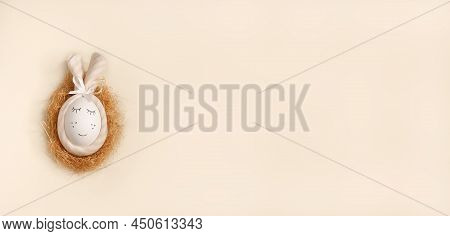 Easter Bunny Egg In A Straw Nest On Light Background
