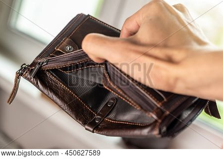The Man Is Holding An Open Empty Brown Leather Wallet Purse. The Concept Of Economic Crisis And Busi