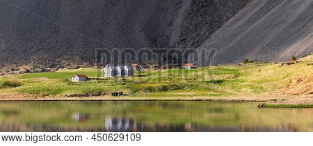 Icelandic homes by the lake shore in the middle of scenic Eystrahorn landscape