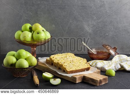 Sliced Apple And Coconut Oaf Cake On Wooden Cutting Board On Dark Background. Copy Space