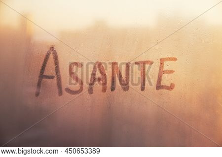 Swahili Word Asante Thanks In English Are Painted On Wet Orange Sunrise Glass Of Window