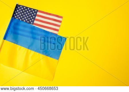 Ukrainian And American Flags During War With Russia. Invasion In Ukraine. Sanctions Against Aggresso