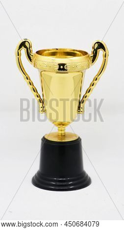 A Vintage Gold Trophy Prize Cup, Symmetrically Designed  Isolated In A White Background