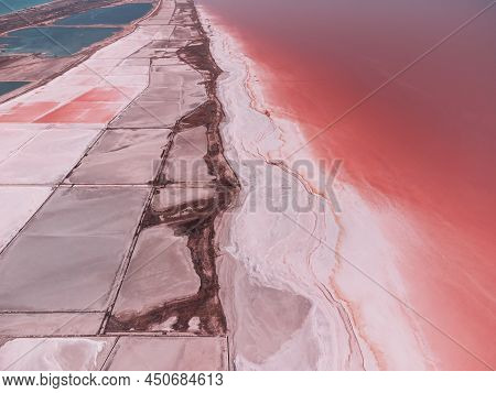Flying Over A Pink Salt Lake. Salt Production Facilities Saline Evaporation Pond Fields In The Salty