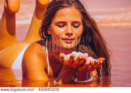 Pink Salt Cristales In Woman Hands. Natural Pink Salt Lake Texture. Salt Mining. Salty Pink Lake Wit