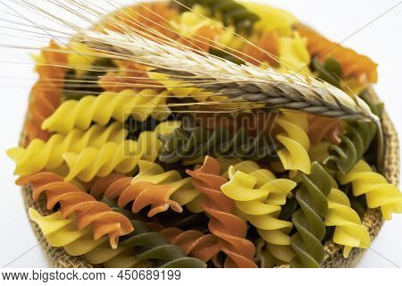 Three Colors Pasta Made From Durum Wheat. Pasta Fusilli Tricolor Background. Abstract Texture Of Col