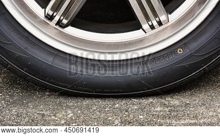 Sidewall Of The  Car Tire With A Low Tire Pressure On The Road,close Up