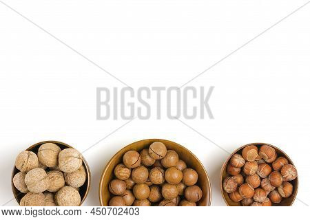 Natural Organic Macadamia, Walnut, Hazelnut Nuts In Wooden Bowl On White Background Flat Lay Top Vie