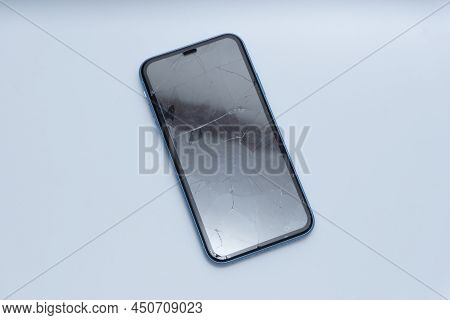 Smartphone With Badly Damaged Screen On A White Background
