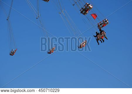 Entertainment Industry With Carousels At Low Altitude Spins Brave Visitors On A Ferris Wheel. Weaker