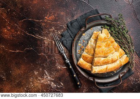Slices Of Baked Round Borek Cheese Pie In Kitchen Tray With Herbs. Dark Background. Top View. Copy S