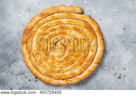 Baked Homemade Traditional Greek Cheese Pie On Kitchen Table. Gray Background. Top View