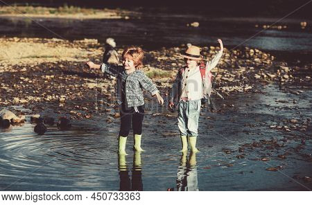 Kids Throwing Rocks. Two Little Sibling Brothers Ans Sister Playing In A River Or Lake On Warm And S
