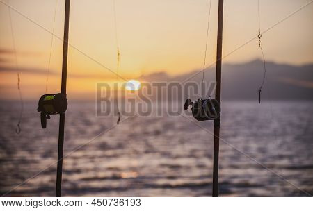 Fishing Rods Over A Beautiful Seascape. Sanset On Sea.