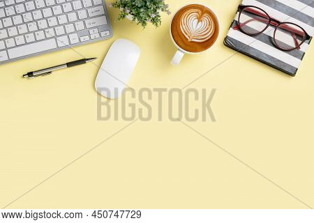Office Desk With Keyboard Computer, Pen, Notebook, Mouse, Cup Of Coffee On Yellowbackground, Top Vie
