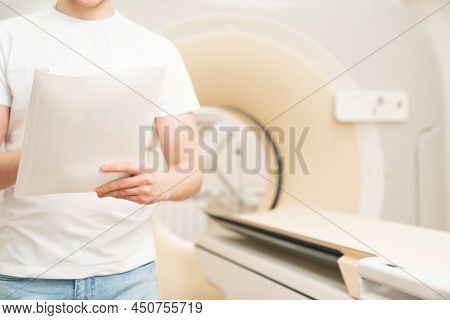 Without A Face. Engineer Fills In Maintenance Documents. Computer Tomograph.