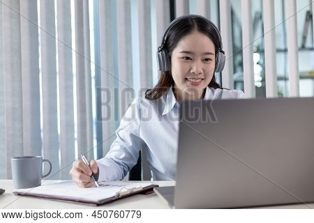 Young Asian woman are greeting friends and manager through video chats and greeting them with cheerf