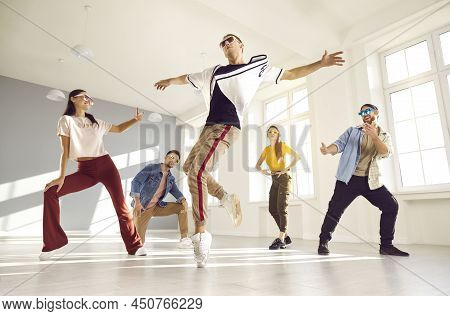 Young Male Dancer Performs Hip Hop Movement On One Leg During Break Dance Lesson.