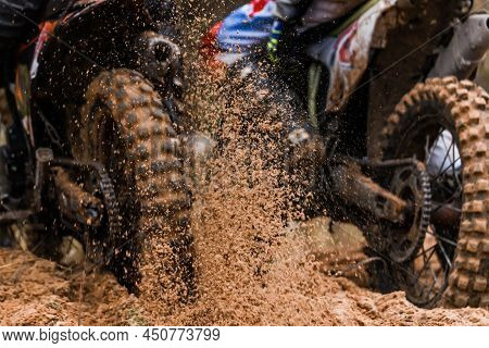 The Wheel Of A Racing Motocross Motorcycle Rides Along The Race Track At High Speed, Dirt And Splash