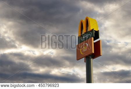 Krasnoyarsk, Russia - March 10, 2022: Mcdonald's Logo With Its Iconic M And Mcdrive Against Stormy S