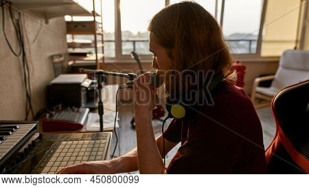 Male Singer Recording On Computer App Singing Song In Microphone At Home Studio. Concept Of Domestic