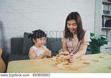 Jenga Games Concept. Asian Daughter And Mother Smiling Happily And Laughing Playing Wooden Jenga Gam