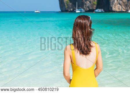 Woman Tourist In Yellow Swimsuit And Hat, Happy Traveller Sunbathing At Maya Bay Beach On Phi Phi Is