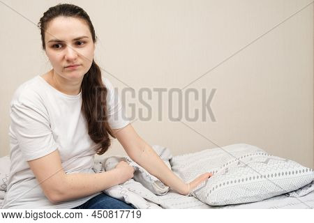 A Sad Woman Sits On A Bed, A Place For Text. Insomnia, Impaired Libido In Women