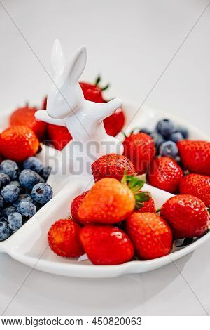 Strawberries And Blueberries In A White Compartmental Dish With Rabbit.