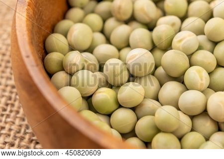 Dry Green Peas. Dried Hard Legumes In Wooden Bowl On Rustic Sackcloth