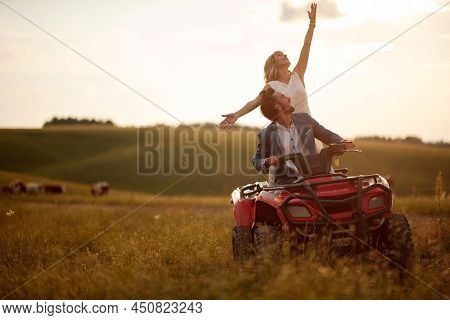 Happy man and woman in love on the mountainon on atv vehicle. Wedding in nature.