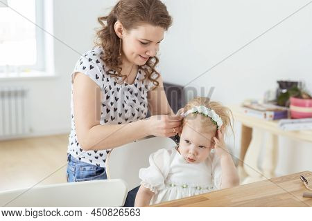 Mother Helps To Put On Cochlear Implant For Her Deaf Little Daughter. Hearing Aid And Deafness Conce