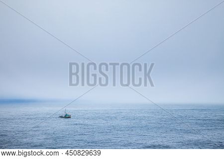 A Fishing Boat In The Fog Just Off The Coast Of Cape Flattery, Washington