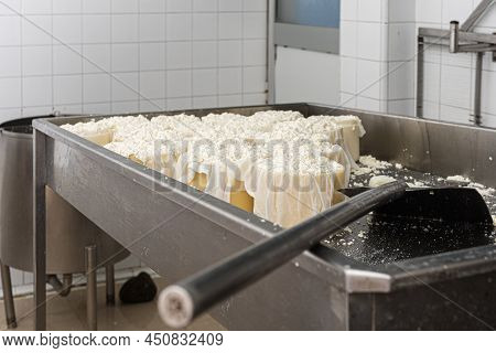 Several Large Curd Moulds In A Metal Container