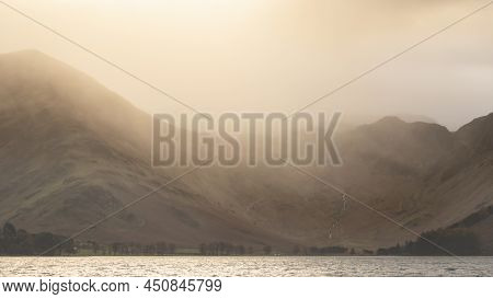 Stunning Autumn Sunrise Landscape Image Of Buttermere In Lake District With Dramatic Stormy Sky