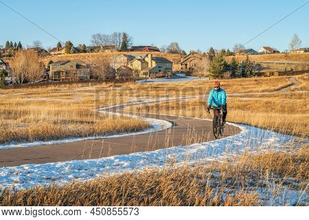 winter afternoon on a meandering biking trail with a senior cyclist riding a gravel bike - Cathy Fromme Prairie Natural Area in Fort Collins, Colorado