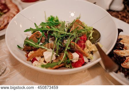 Salad With Arugula, Cheese And Meat On A White Plate